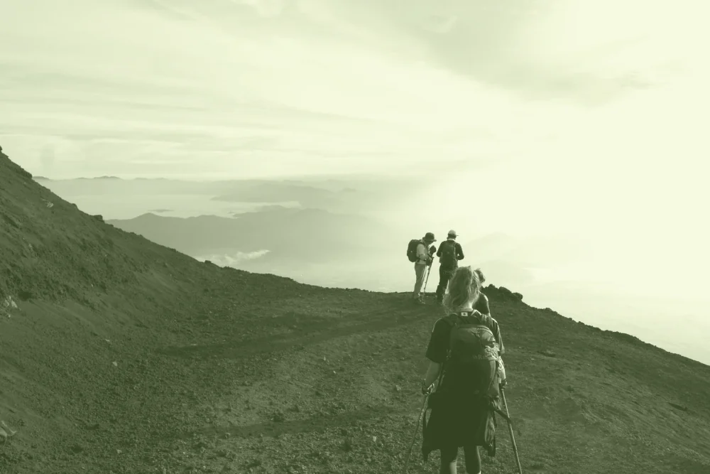 Un groupe de marcheurs descendant un sentier de montagne, au petit matin.