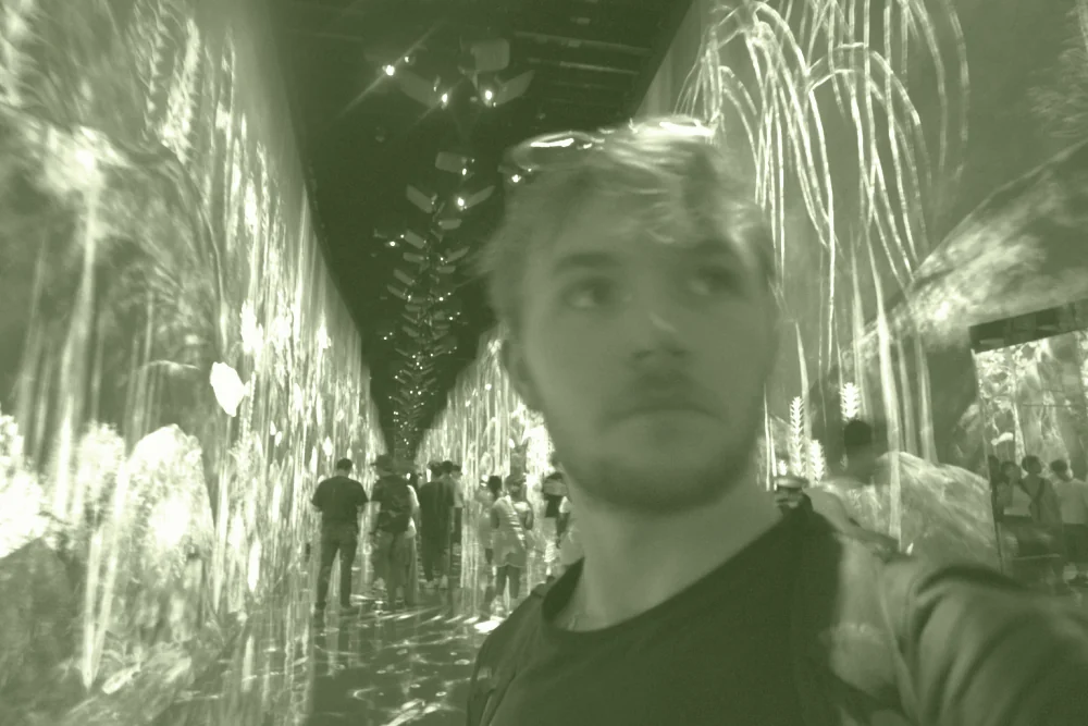 Aodren Le Pesquer dans une installation numérique immersive, entouré d'écrans.